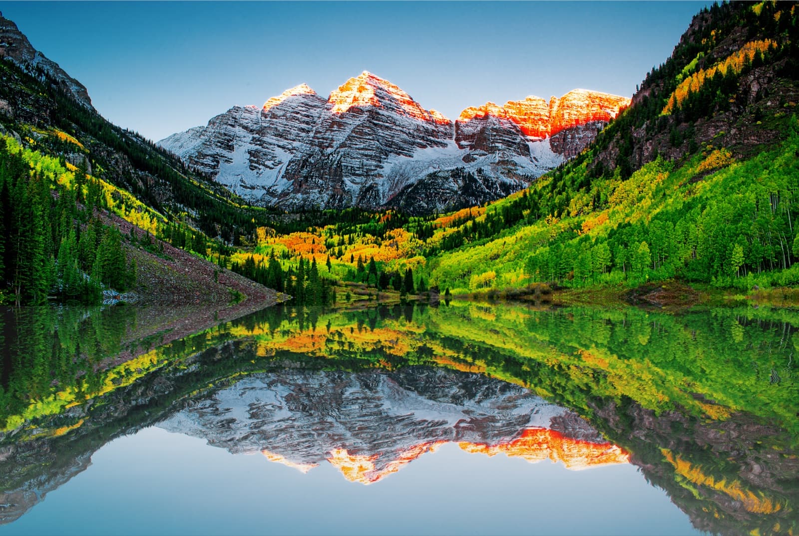 Maroon Bells reflected in a lake at sunrise, Colorado